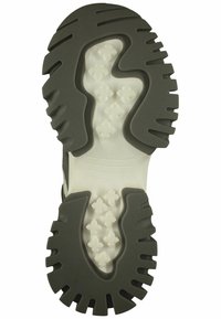 Semelle en caoutchouc avec des sections contrastantes de gris foncé et de blanc. Caractérisée par des rainures profondes et des motifs texturés pour une meilleure adhérence et traction.