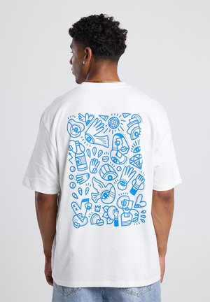 Camiseta de algodón blanca con un diseño gráfico azul en la parte posterior, que consiste en formas abstractas, ojos, manos y varios patrones.
