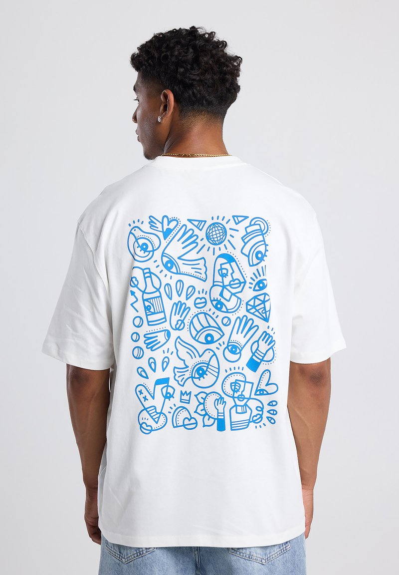 White cotton t-shirt featuring a blue graphic design on the back, consisting of abstract shapes, eyes, hands, and various patterns.