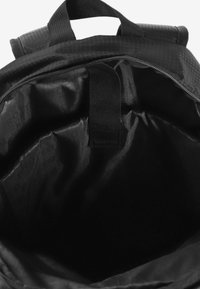 Czarny plecak o teksturowanej powierzchni, z podwójnymi uchwytami i zamkiem u góry; wnętrze jest gładkie i również czarne.