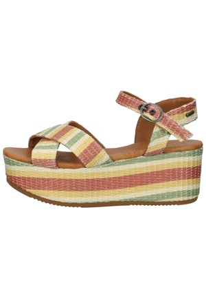 Platform sandal med brede krydsede stropper og ankel spænde, præget af vævet tekstur og vandrette striber i grønne, gule og koralfarvede nuancer.