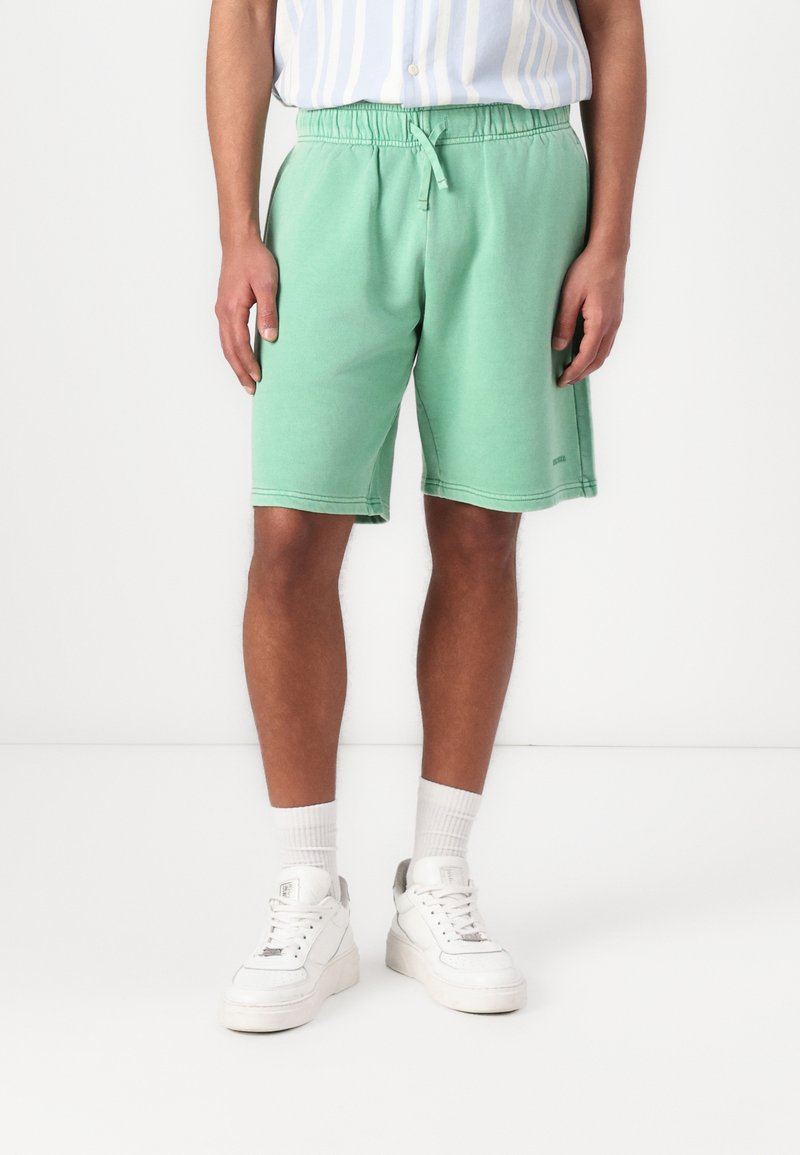 Groene katoenen blend short met een elastische tailleband en trekkoord, voorzien van een relaxte pasvorm en zijzakken. Draag het met witte sneakers.