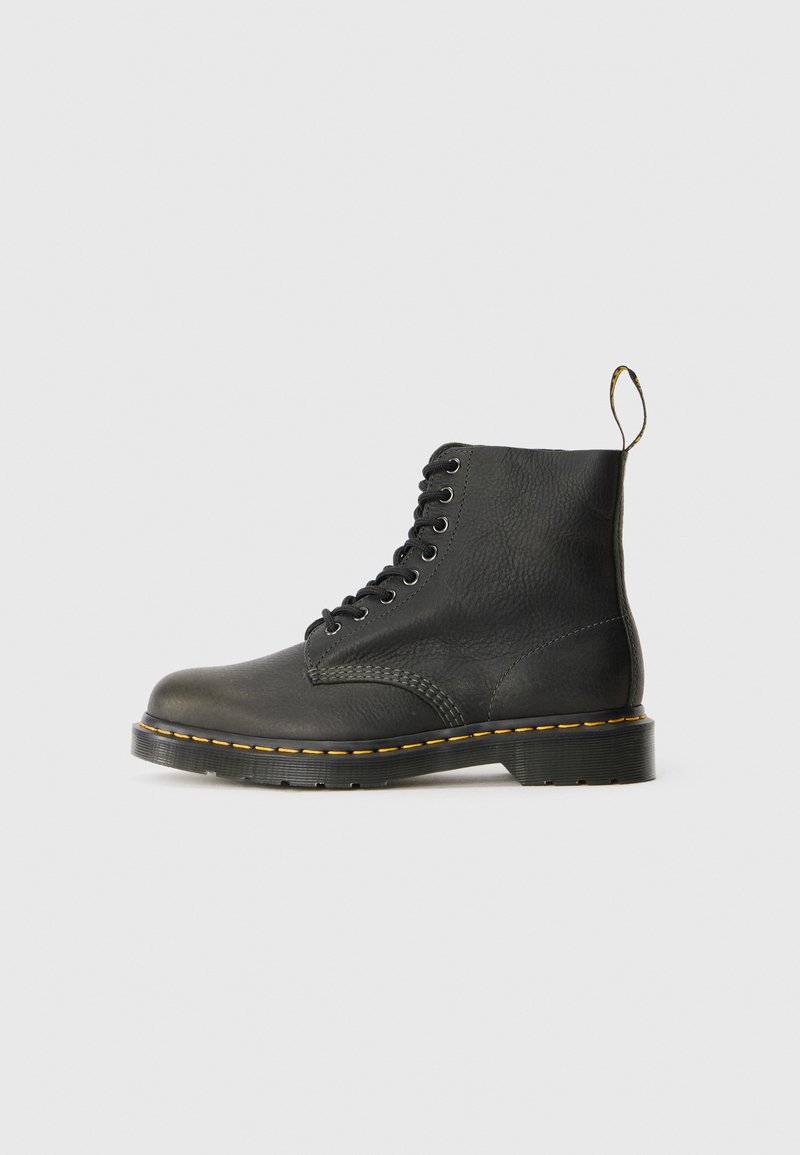 Bottine en cuir noir avec une surface texturée, bout rond, coutures jaunes et lacets noirs. Tirant à l'arrière pour un enfilage facile.