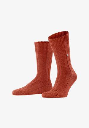 Calzini a coste, fino al polpaccio, di un caldo colore terracotta. Realizzati in un tessuto morbido con un design aderente e un piccolo dettaglio del logo sul lato.