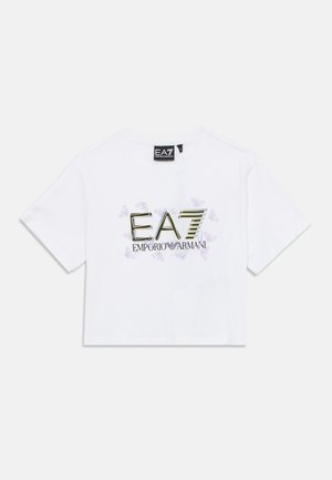 T-shirt branca cropped de algodão, com estampa gráfica dourada e roxa e logotipo "EA7 Emporio Armani" na parte da frente.