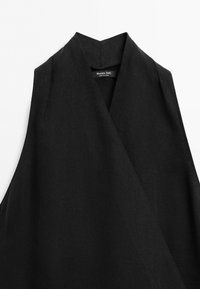 Zwarte lange mouwloze vest met brede sjaalkraag, gemaakt van gestructureerde stof, label Massimo Dutti, maat small.