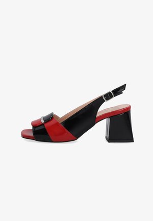 Schwarze und rote synthetische Slingback-Absätze mit einem quadratischen Blockabsatz, die eine glänzende Oberfläche und eine Schnallenakzentuierung am vorderen Riemen aufweisen.