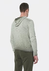 Lichtgroene hoodie met een gestructureerde afwerking, geribbelde mouwen en zoom, met een opening aan de achterkant van de nek voor de capuchon.