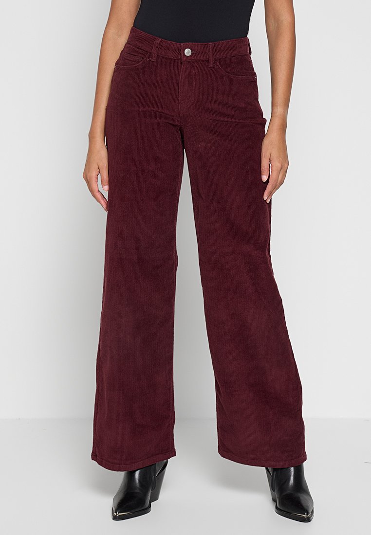 Bordeaux corduroy wijde pijpen broek met een hoge taille, voorzakken en een gestructureerde afwerking. Gecombineerd met zwarte haklaarzen.