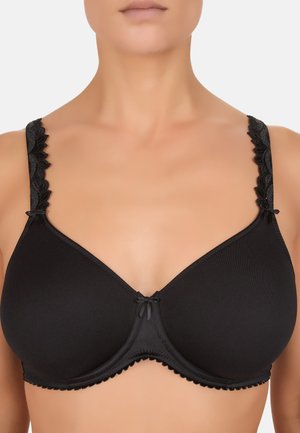 Sort undertrøje med bøjle, glatte skåle, blomsterblonde stropper samt små dekorative sløjfer på stropperne og midten foran, båret på overkroppen.