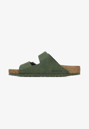 Zelené sandále Birkenstock s dvoma vypichovanými popruhmi, korkovou stielkou a textúrovaným vonkajším povrchom. Podošva je plochá s nekĺzavým dizajnom.