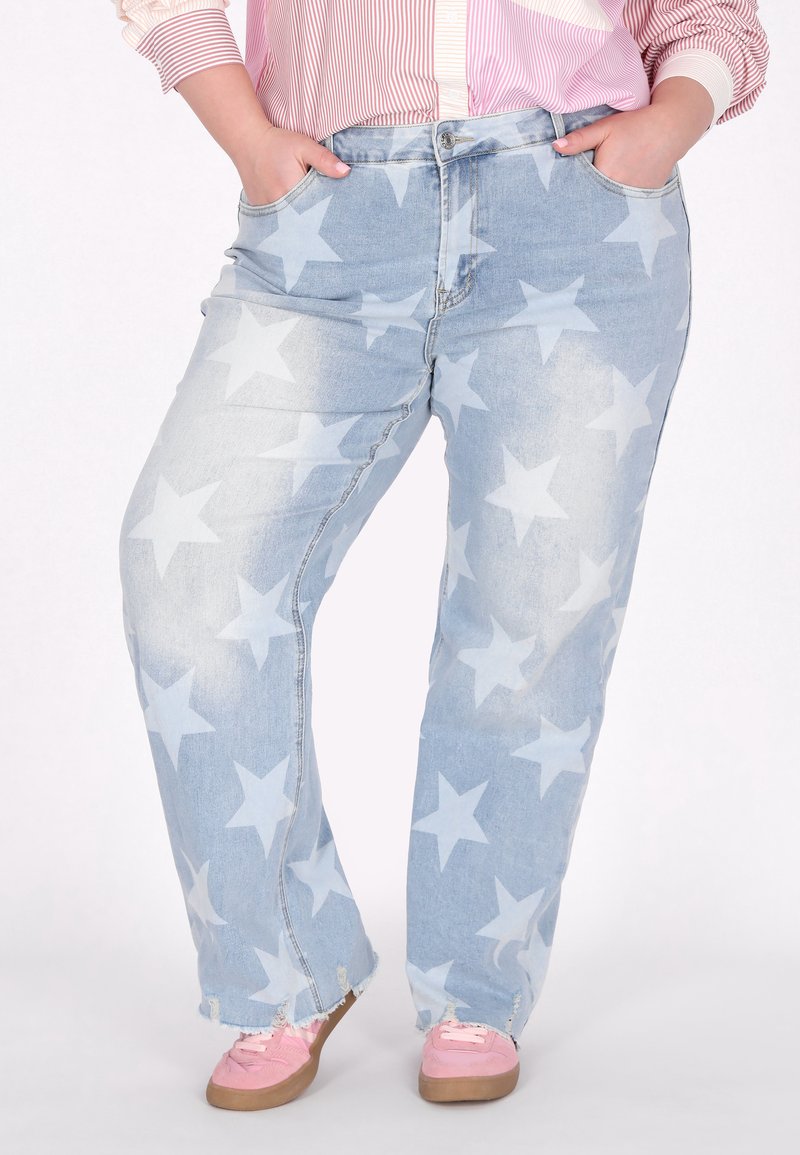 Jeans in denim azzurro chiaro con un motivo a stelle sbiadito, dal fit rilassato, tasche frontali e orlo strappato, abbinati a scarpe rosa.
