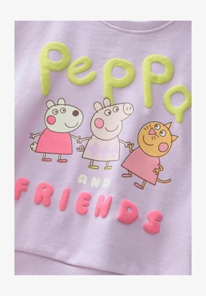 Gaiši purpura treniņjak ar krāsainiem, izceltajiem grafikas attēliem, kuros ir trīs multfilmu varoņi, un lieliem burtiem, kas saka "Pepija un draugi."