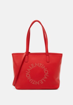 Rote Leder-Tote mit doppelten Trägern, ausgestattet mit einem kreisförmigen Stud-Logo-Design auf der Vorderseite. Glatte Textur und strukturierte Form.
