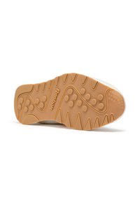 La suela del zapato presenta una parte inferior de goma texturizada con patrones circulares y en zigzag, que indican agarre y durabilidad. Se aprecia un sutil branding.