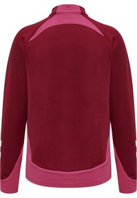 Chaqueta deportiva marrón rojizo con detalles en rosa; cuenta con un cuello alto, mangas largas, tejido texturizado y detalles de malla en los hombros y los costados.