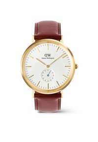 Reloj en tono dorado con una esfera texturada blanca, delgados marcadores de hora dorados y una pequeña manecilla de segundero azul. Correa de cuero marrón con detalle de costura.