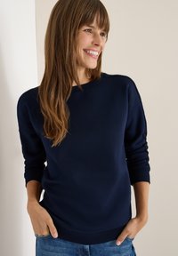 Marineblå sweatshirt med ribbede manchetter og halsudskæring; blødt stof med teksturerede detaljer på skuldrene; afslappet pasform.