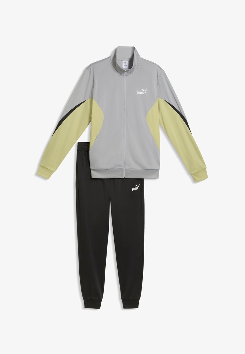 Survêtement avec veste gris clair, jaune et noire avec fermeture éclair à l'avant et pantalon noir, tous deux marqués de logos Puma blancs.