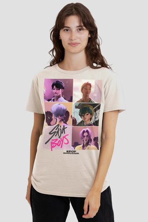 Woman wearing a beige t-shirt featuring six K-pop demon hunter animated male characters in colorful panels with "Saija Boys" text.