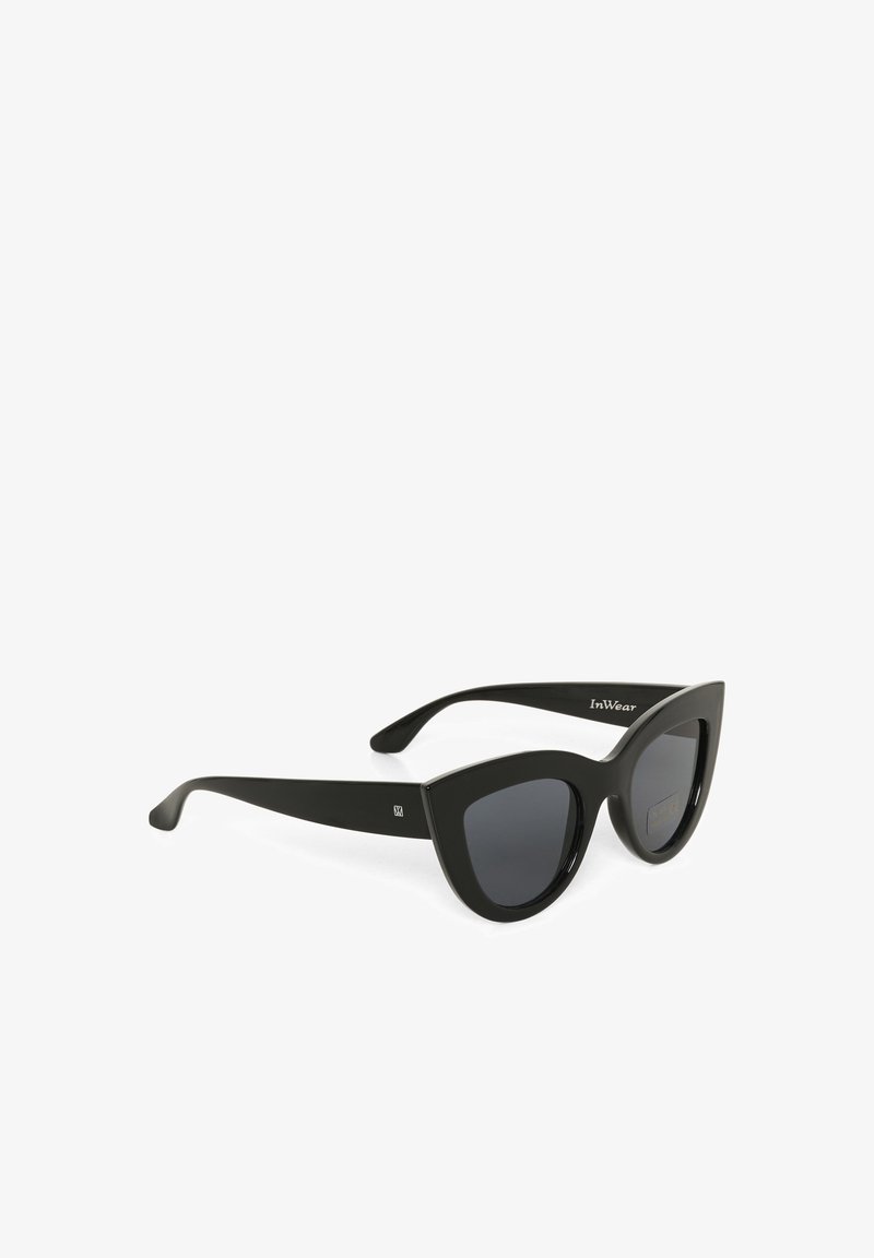 Gafas de sol estilo gato negro con lentes oscuros. Están hechas de plástico, con una superficie lisa y detalles del logo en las patillas.
