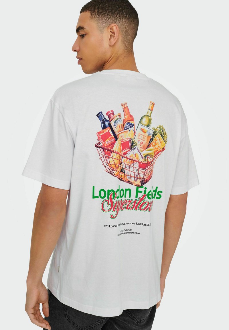 Witte katoenen t-shirt met een kleurrijke afbeelding van boodschappen in een draadmand. Inclusief de tekst "London Fields Superstore" in het groen.