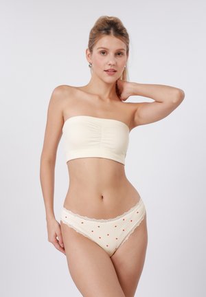 Κορυφή σε κρεμ απόχρωση χωρίς τιράντες με ρεγμένο μπροστινό μέρος και ταιριαστά εσώρουχα με δαντέλα στο τελείωμα και κόκκινες βούλες, με απαλή ριμπ υφή.