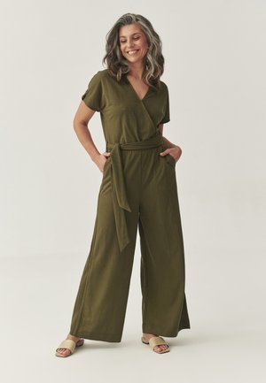 Olivengrøn, kortærmet jumpsuit med omslag, bælte der bindes i taljen, sidelommer og bred bukseben. Glat stoftekstur.