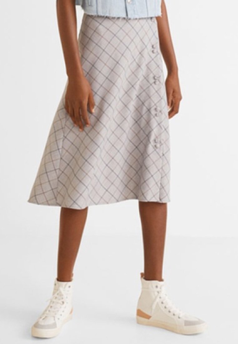 Une jupe trapèze mi-genou de couleur gris clair avec un motif à carreaux en gris foncé et beige, ornée de boutons sur le devant.