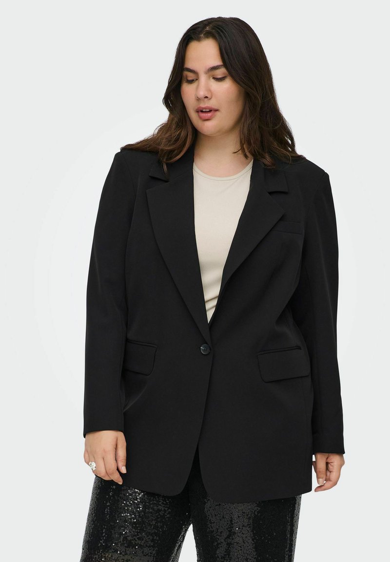 Melnas žaketes ar vienu pogu, ar izgriezumu un divām priekšējām kabatām, apvienojot ar bežīgu blūzi un melnajām biksēm ar mirdzošiem akcentiem.