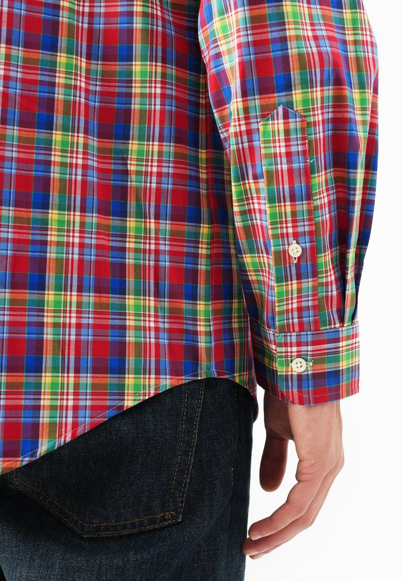 Koszula w kratkę w czerwone, niebieskie, zielone i żółte wzory, z długimi rękawami i zapinanymi mankietami, wykonana z lekkiego materiału, z wygiętym dołem.