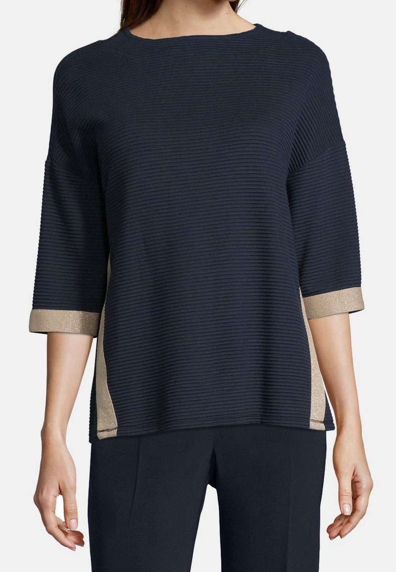 Marinblått ribbat tröja med 3/4 långa ärmar, guldglittrande detaljer vid muddar och sidor, rund krage, avslappnad passform och strukturerad tyg.