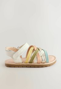 Sanda de múltiples colores con correas sintéticas blancas y una plantilla acolchada beige. Presenta acentos en oro, verde, rosa y azul en un diseño entrecruzado.
