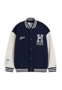 Μπλε ναυτικό και λευκό varsity μπουφάν με ριγέ γιακά και μανσέτες, patches Snoopy, λογότυπο Tommy Hilfiger και κλείσιμο με κουμπιά στη μέση μπροστά.