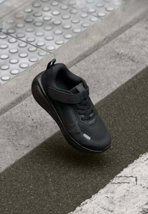 Czarne sportowe buty z teksturowanym materiałem, zapięcie na pasek i sznurówki. Posiadają zaokrągloną podeszwę i subtelne logo po bokach.