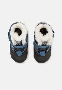 Bottines pour tout-petits bleu et noir avec une doublure blanche pelucheuse. Les caractéristiques incluent des lacets et une sangle, offrant un soutien structuré et de la chaleur.