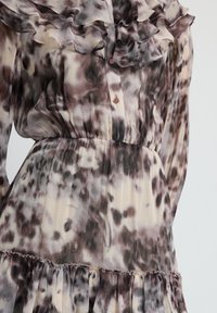 Abito lungo e trasparente con colletto arricciato, chiusura a bottoni frontale, vita elastica e stampa astratta marrone e beige con finitura texturizzata.