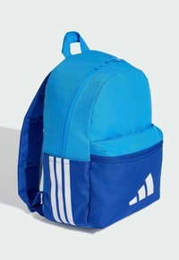 Modrý batoh s kulatým tvarem, vyrobený z odolné látky. Má hlavní kapsu na zip, přední kapsu a bílé pruhované akcenty.