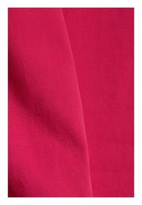 Gros plan d'un tissu rose vif avec une texture côtelée diagonale fine et un pli subtil au centre.