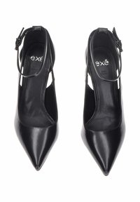 Scarpe nere con tacco alto dal design a punta, realizzate in pelle lucida, con cinturino alla caviglia e fessure laterali aperte.