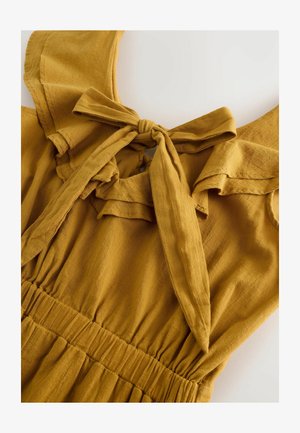 Mustársárga ruha masni részlettel, fodros gallérral és gyűrött derékpánttal. Puha anyag, sima textúrával és lágy vonalakkal.