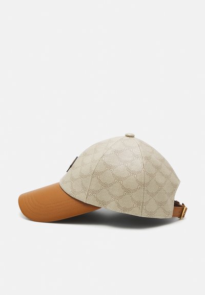 Casquette avec un dessus en tissu beige à motifs, visière marron et accent. Présente une visière courbée et une sangle ajustable à l'arrière.