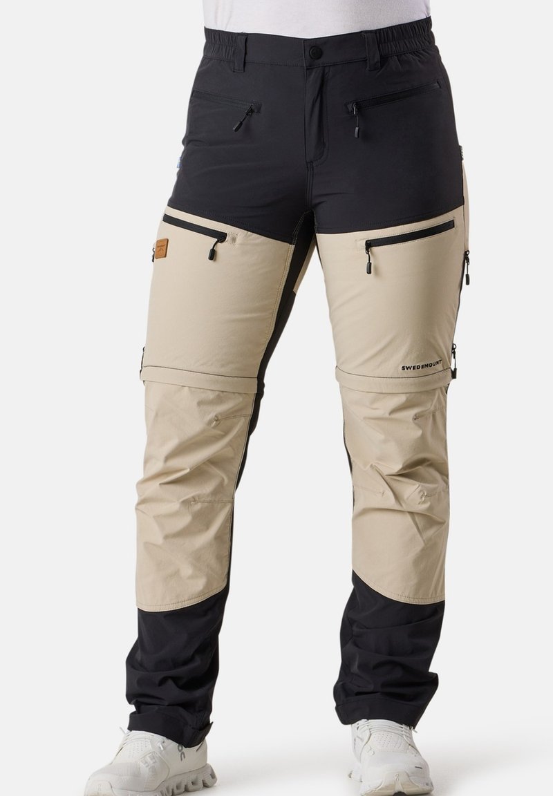 Lätta utomhusbyxor i svart och beige, med fickor med dragkedja, elastisk midja och justerbara benslut för en säker passform.