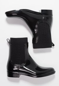 Black ankle rain boots with a glossy finish, featuring a stretchy knit panel and pull tab for easy wear, set against a white background.