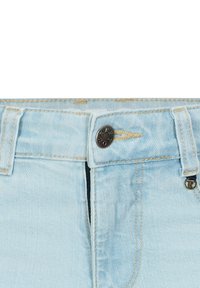 Jeans in denim azzurro chiaro con chiusura frontale a bottoni, zip e cuciture a contrasto. Presenta passanti per cintura e tasche laterali.