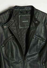 Czarna skórzana kurtka z kołnierzem stojącym, pikowanymi akcentami na ramionach oraz dwoma kieszeniami na zamek. Wnętrze posiada wykończenie z nadrukiem marki.