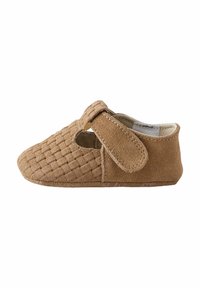 Chaussure en suède brun avec texture tissée, bout arrondi et une sangle auto-agrippante. Présente des côtés découpés, un doublure douce et une semelle plate.
