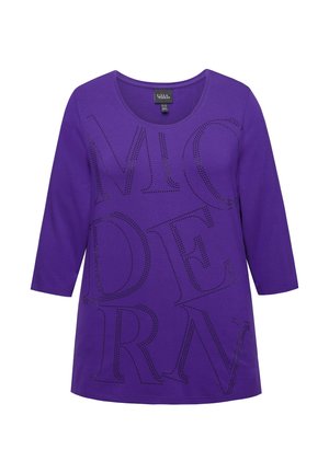 Violetti, pitkähihaista t-paitaa, jossa on pyöreä kaula-aukko. Esittelee suurta, mustaa rei'itettyä tekstiä, jossa lukee "MODERN." Pehmeä kangastuntuma.