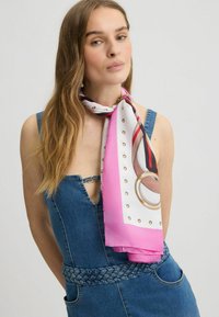 Zijden sjaal met een roze en witte ontwerp, voorzien van gouden accenten, cirkelvormige patronen en een glanzende afwerking, geknoopt rond de hals.