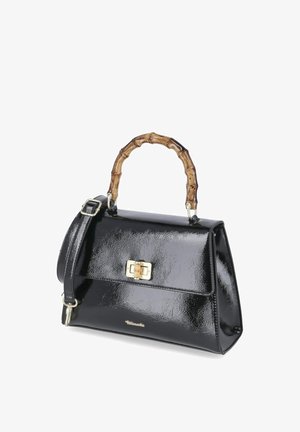 Glänzende schwarze Handtasche mit bambusartigem, festem Griff, goldfarbenem Verschluss und verstellbarem Schulterriemen auf weißem Hintergrund.